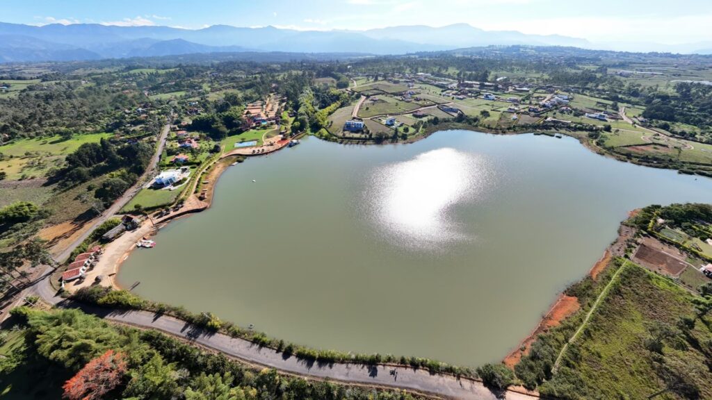 Vista aérea del lago rodeado de áreas verdes y construcciones